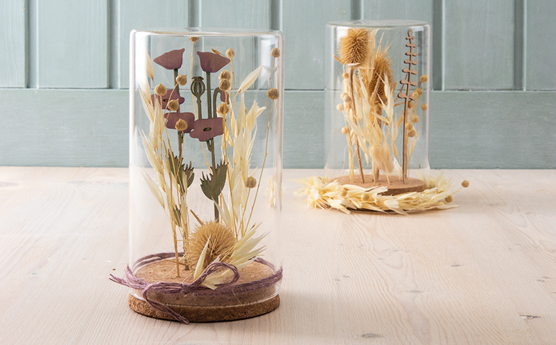 Trockenblumen und Holzstecker im Glasgefäß
